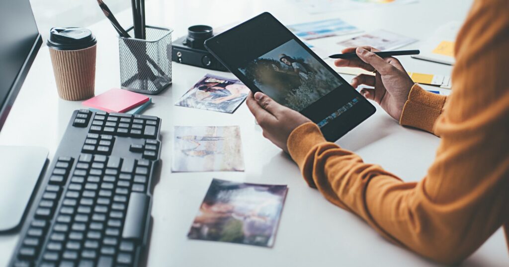 A person using a tablet computer at a desk. Enhance your reach with Multi-Format Ads.