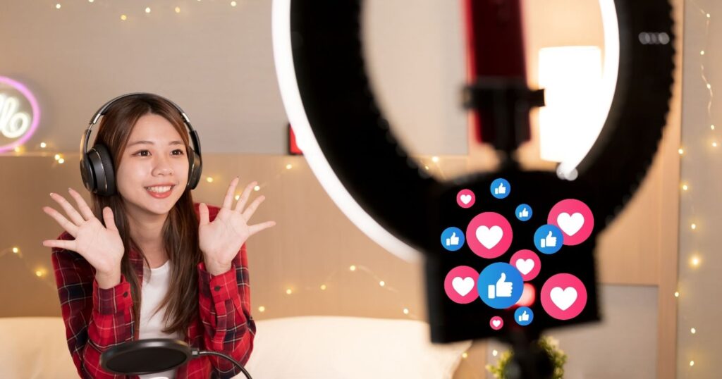 A woman sitting on a bed wearing headphones, engrossed in audio content on mainstream platforms.