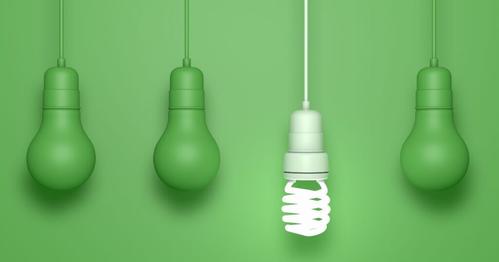 Green light bulb with four colored bulbs: red, blue, yellow, and orange. Energy efficient lighting solution.