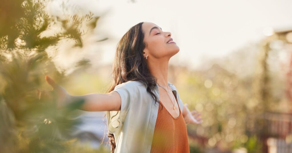 A person holding a bouquet of flowers and smiling, expressing gratitude for something or someone.