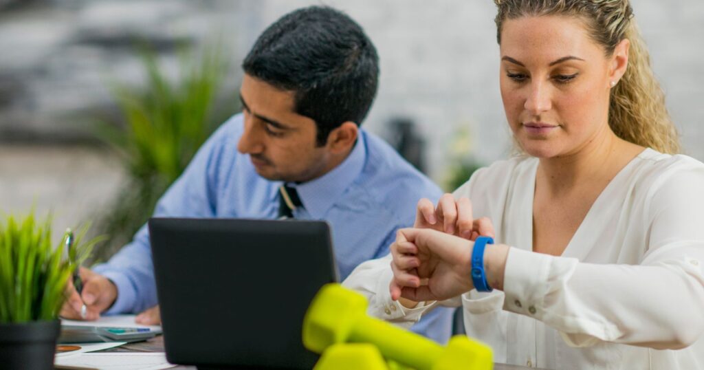 A busy entrepreneur working on a laptop while juggling multiple tasks and managing work-life balance.